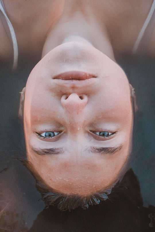 Women floating in water with her face peaking through 