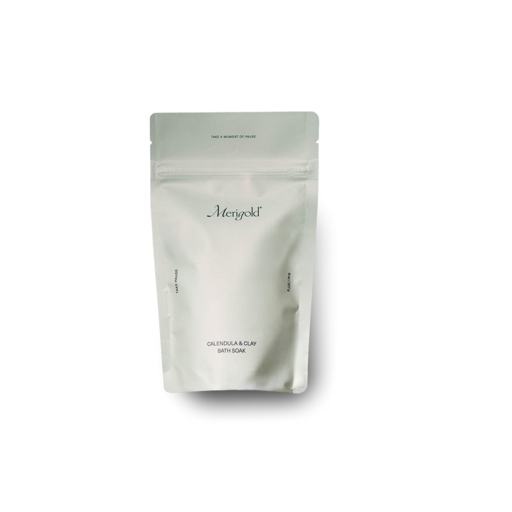 Merigold Calendula & Clay Bath Soak in minimalist faint green resealable bag with subtle branding and clean, modern label design, featuring skin-loving ingredients like calendula petals and French green clay, photographed on white background.