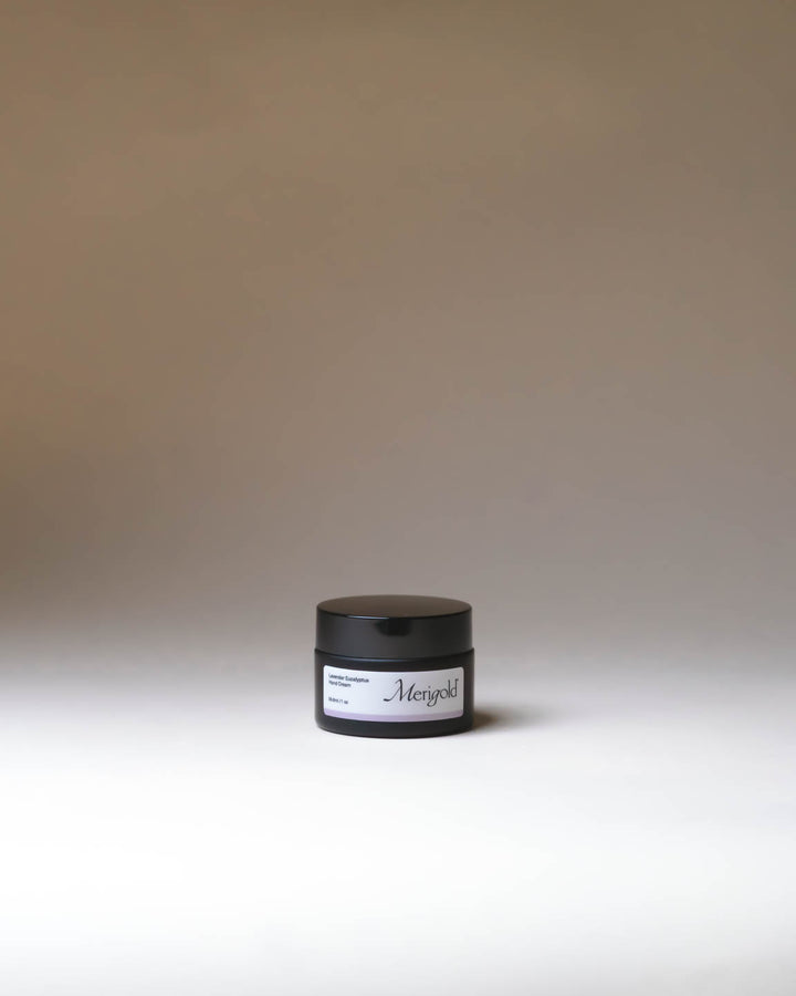 Merigold Lavender Eucalyptus Hand Cream in amber jar on minimal neutral background, soothing hydrating clean skincare.
