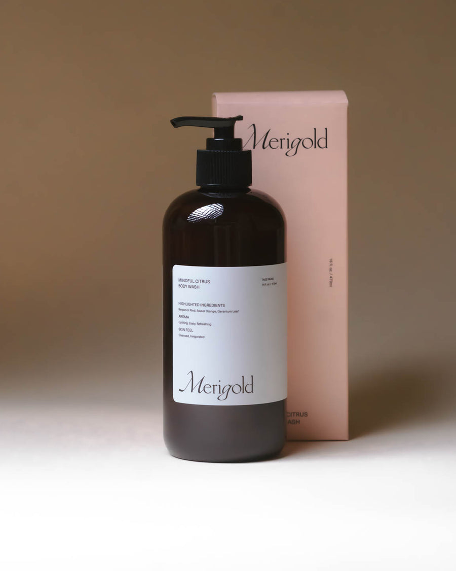 Merigold Mindful Citrus Body Wash with orange packaging box, energizing citrus body cleanser in amber pump bottle.