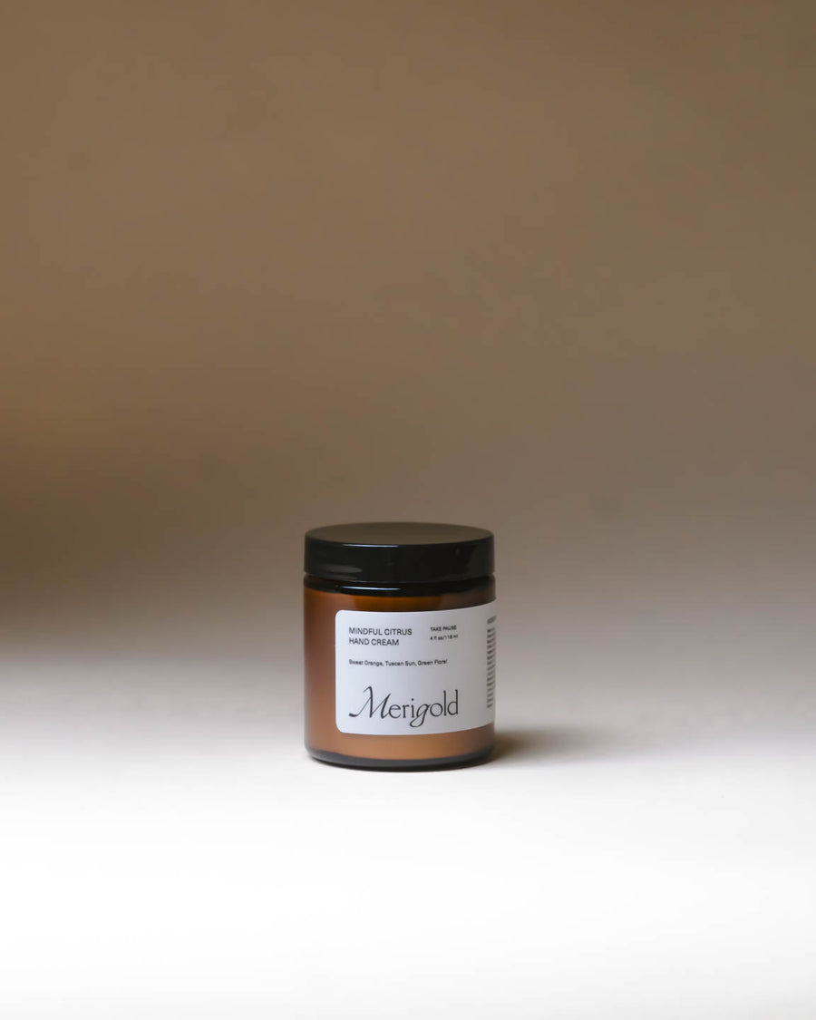 Merigold Mindful Citrus Hand Cream in amber jar on minimal background, bright citrus hydrating hand cream.
