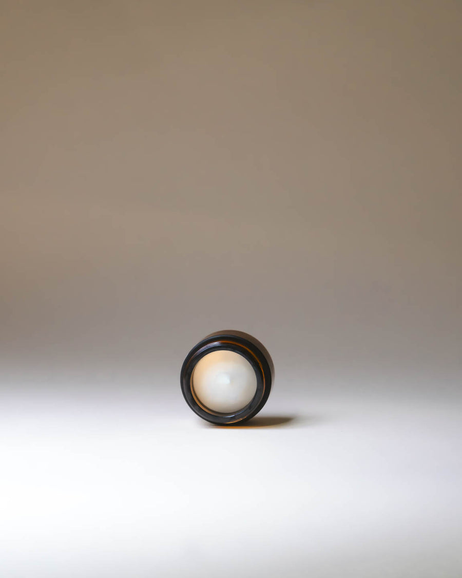 Open jar of Merigold Mindful Citrus Hand Cream showing velvety white cream texture, nourishing citrus formula.