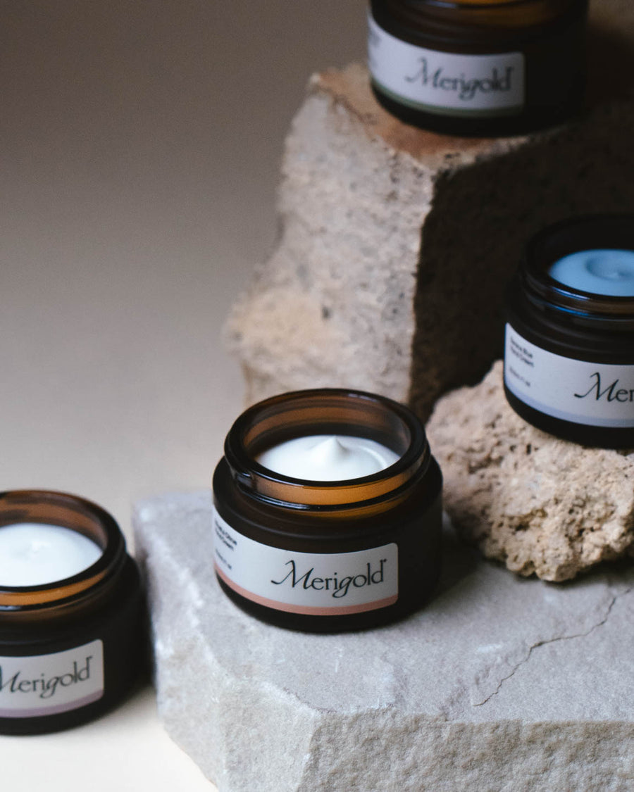 Close-up of Merigold mini hand cream collection on stone featuring Serene Blue, Mindful Citrus, Woodland Zen, and Lavender Eucalyptus.